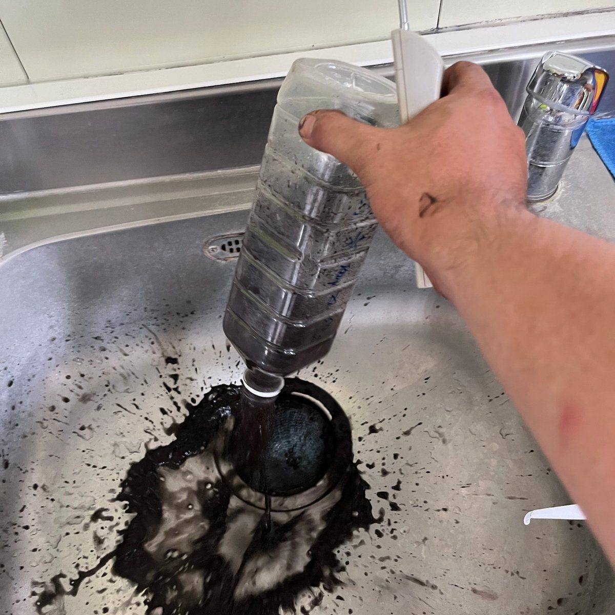 水管清洗過程中,黑水如墨汁般從出水口噴出,清楚可見污染程度